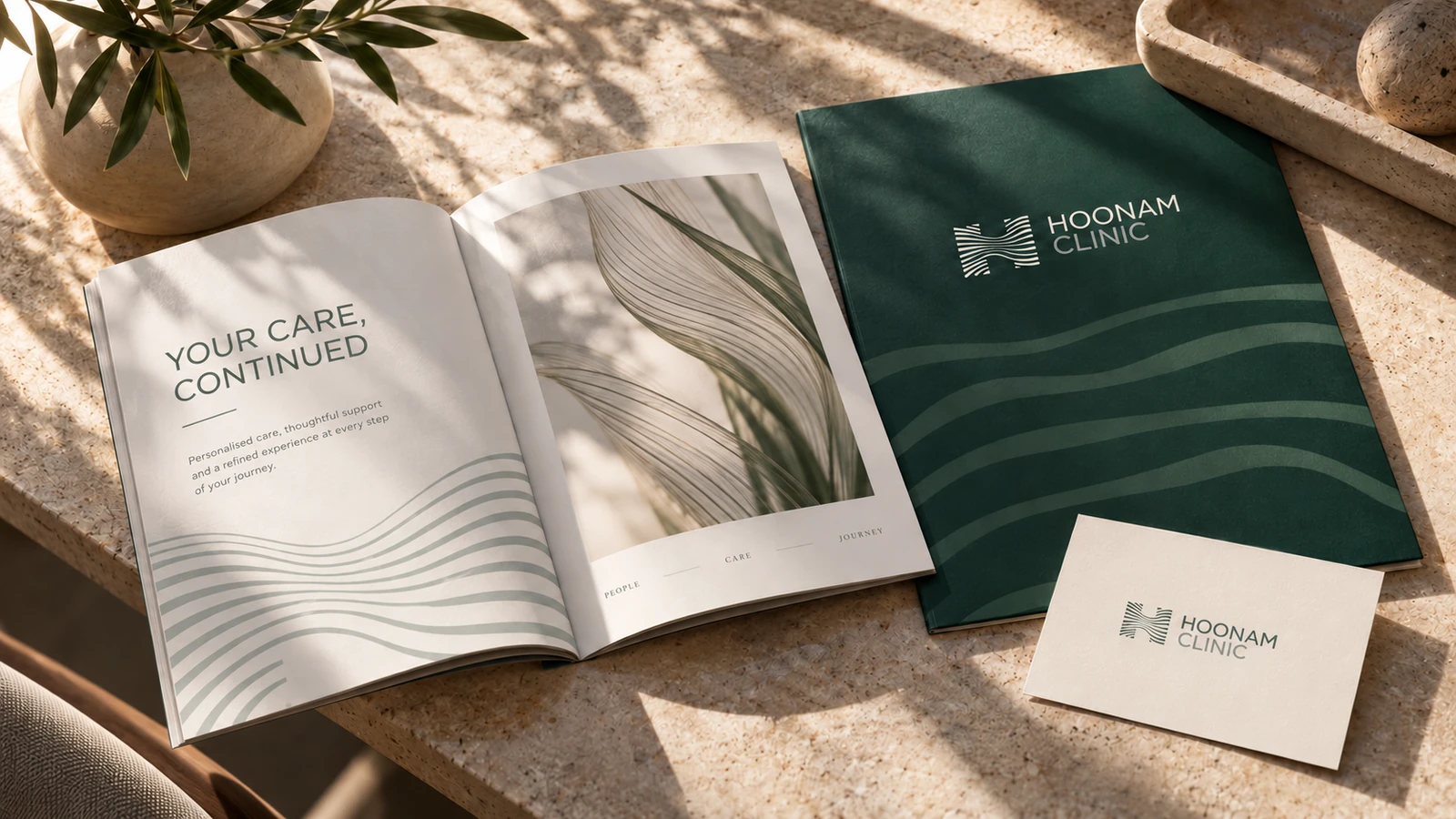 Hoonam patient booklet and green consultation folder on natural stone