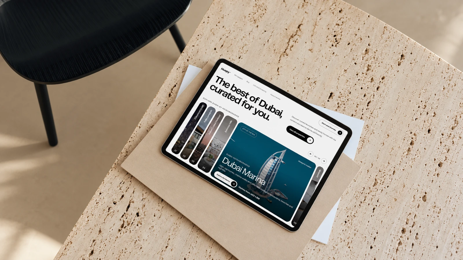 Huspy neighbourhood exploration on a tablet on a travertine desk