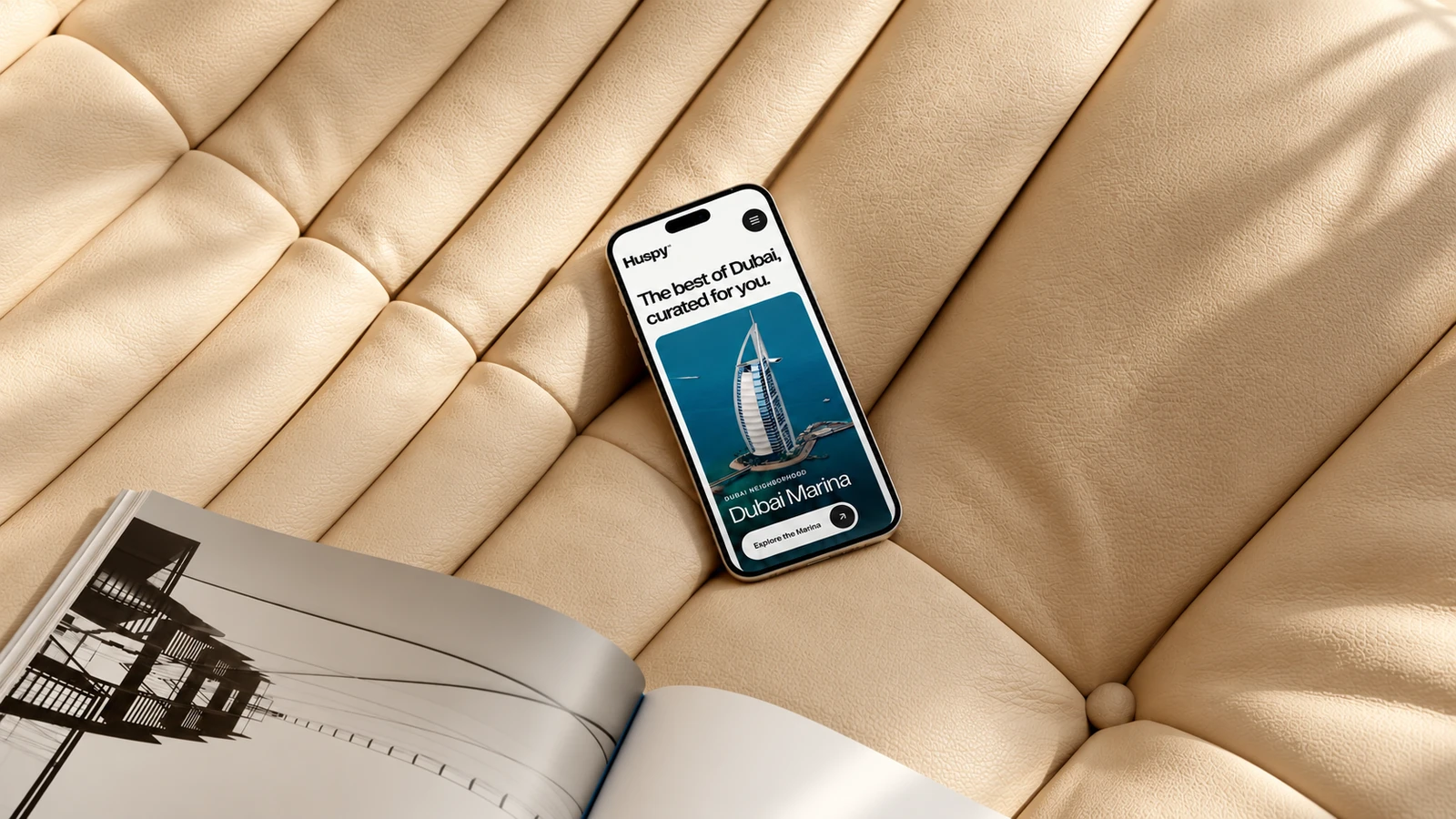 Huspy neighbourhood mobile presentation on a phone on a cream sofa